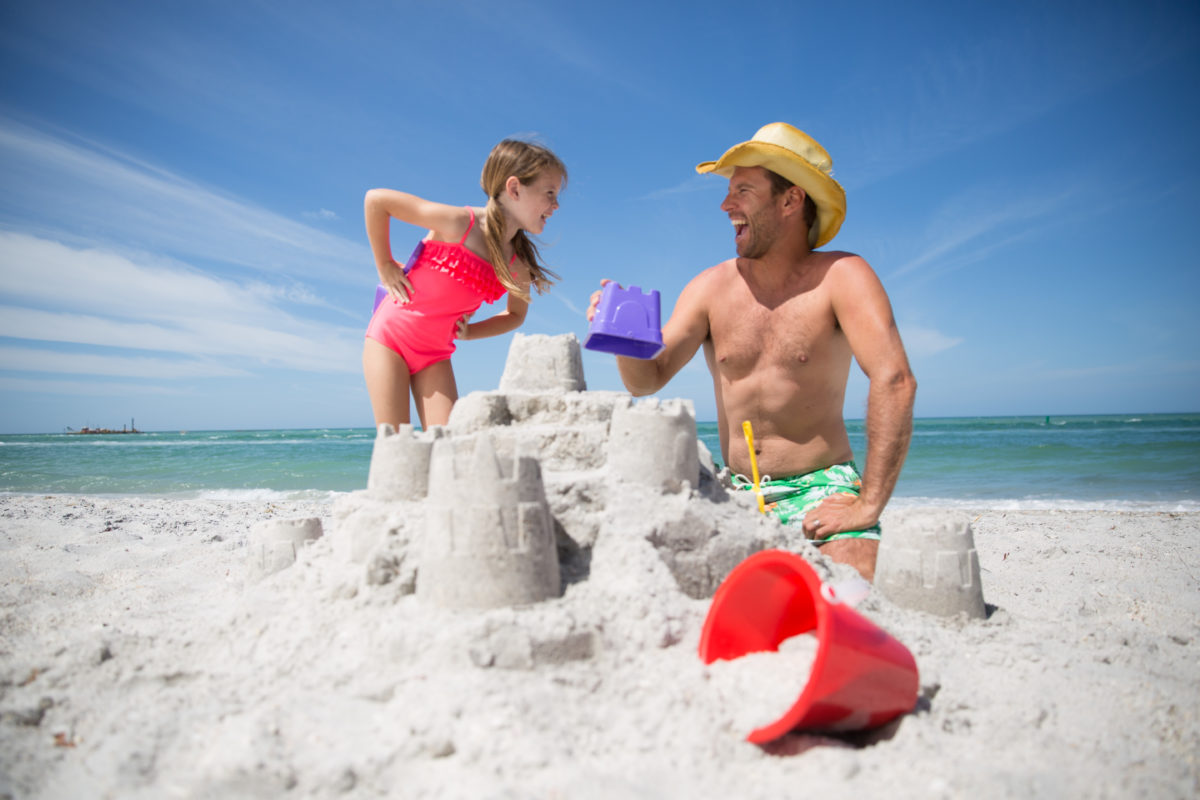 dad and daughter making a sandcastle
